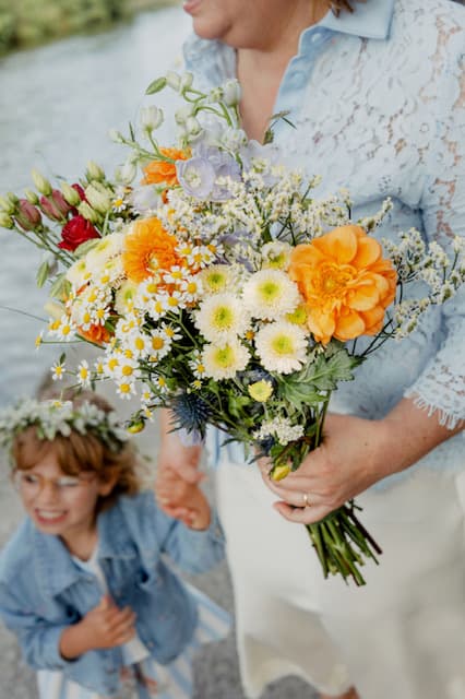 Bruidsboeket met madeliefjes en oranje dahlia's